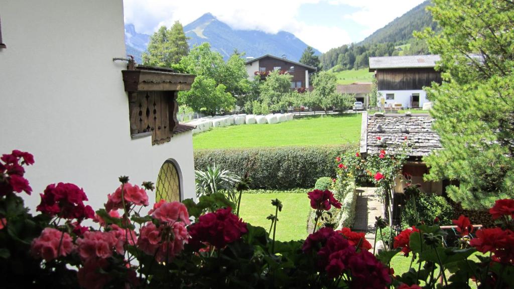 a garden with flowers in the foreground and mountains in the background at Haus Krößbacher in Fulpmes