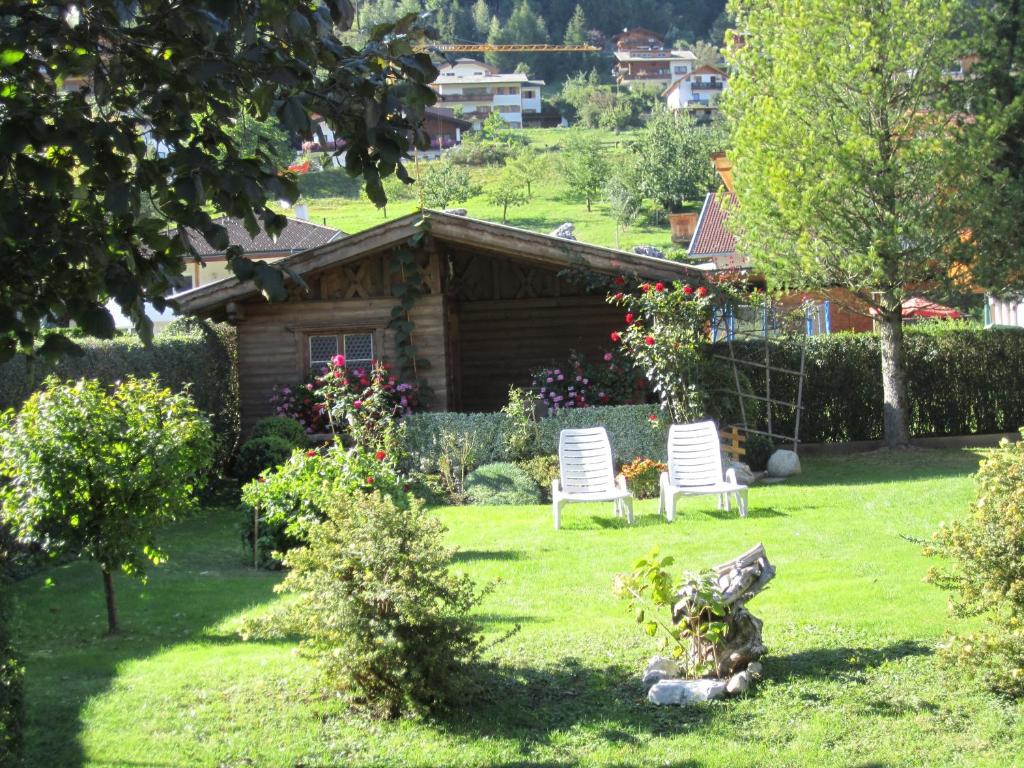 a garden with two chairs and a log cabin at Haus Krößbacher in Fulpmes