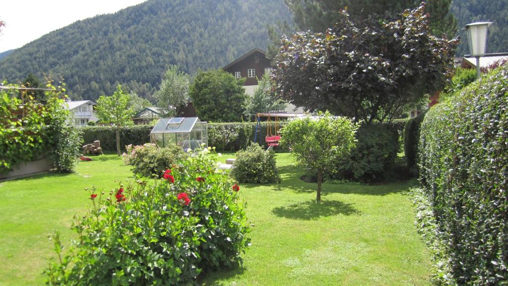 a garden with bushes and trees and a house at Haus Krößbacher in Fulpmes