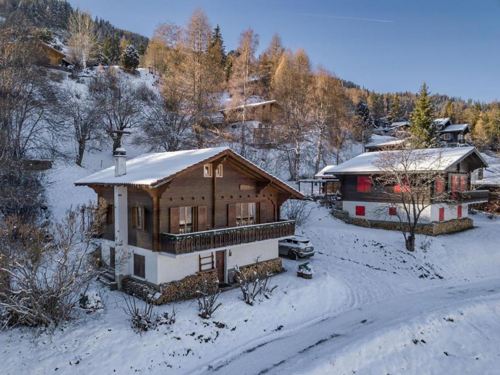 Casa de madera grande con nieve en el suelo en Chalet Noisette Authentic Swiss chalet Perfect for families, en Riddes