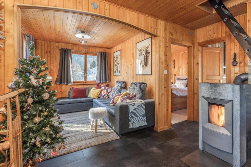een woonkamer met een kerstboom en een open haard bij Chalet Noisette Authentic Swiss chalet Perfect for families in La Tzoumaz