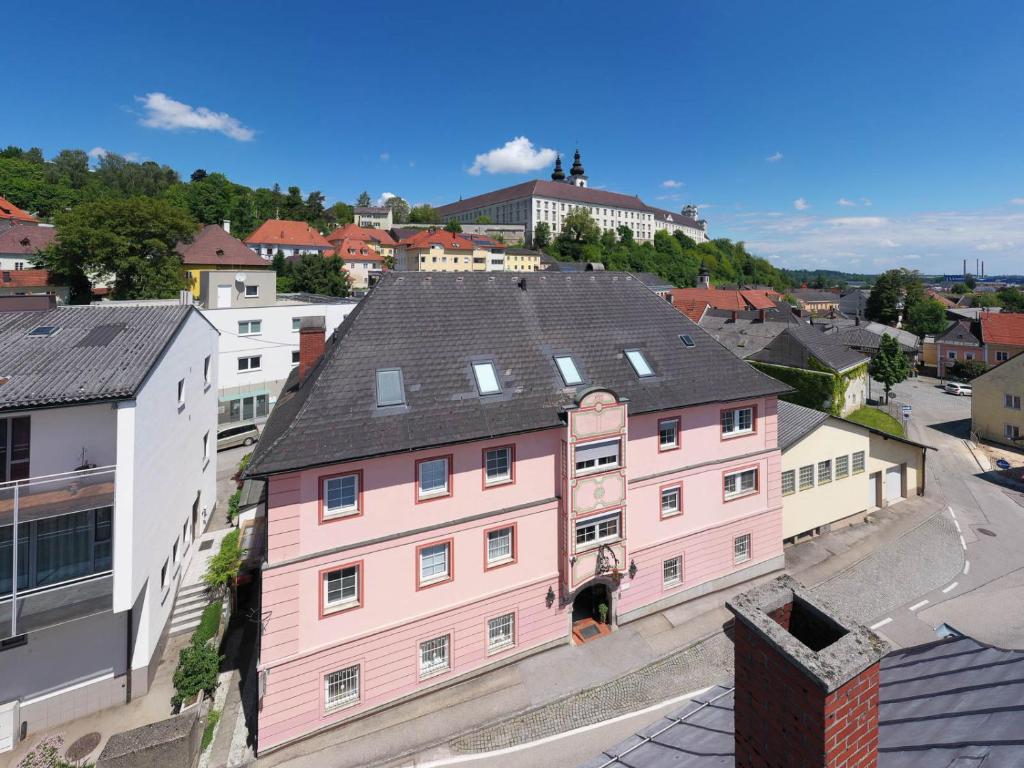 a pink building in the middle of a city at Hotel Schlair in Kremsmünster