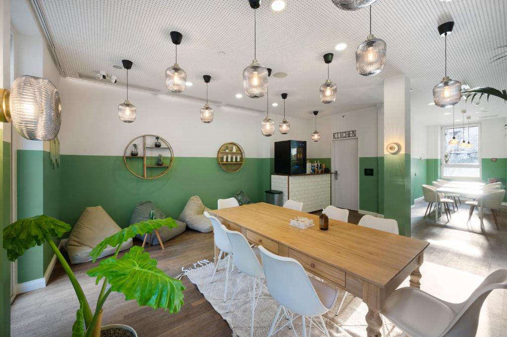una sala da pranzo con tavolo in legno e sedie bianche di Becozy Self Check-in Pop-Up Hotel Basel a Basilea