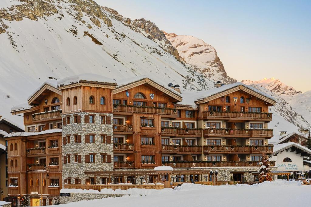 een groot gebouw voor een met sneeuw bedekte berg bij Airelles Val d'Isère in Val dʼIsère