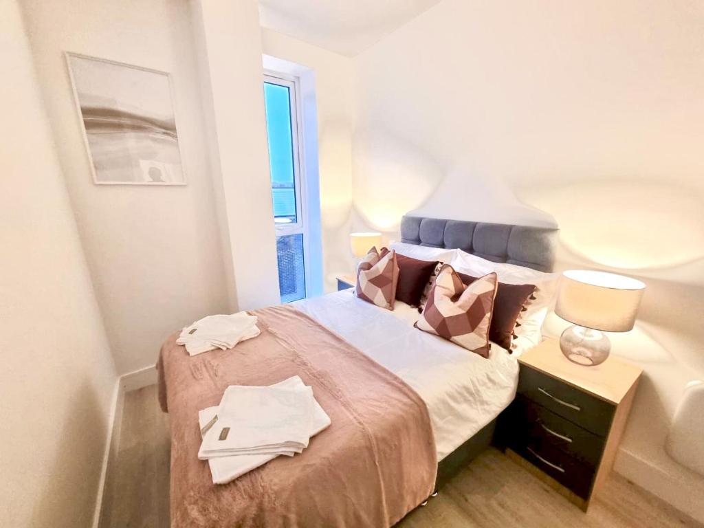 ein kleines Schlafzimmer mit einem Bett mit Handtüchern darauf in der Unterkunft Elevate at Fleet Heights Apartment Seven in Fleet