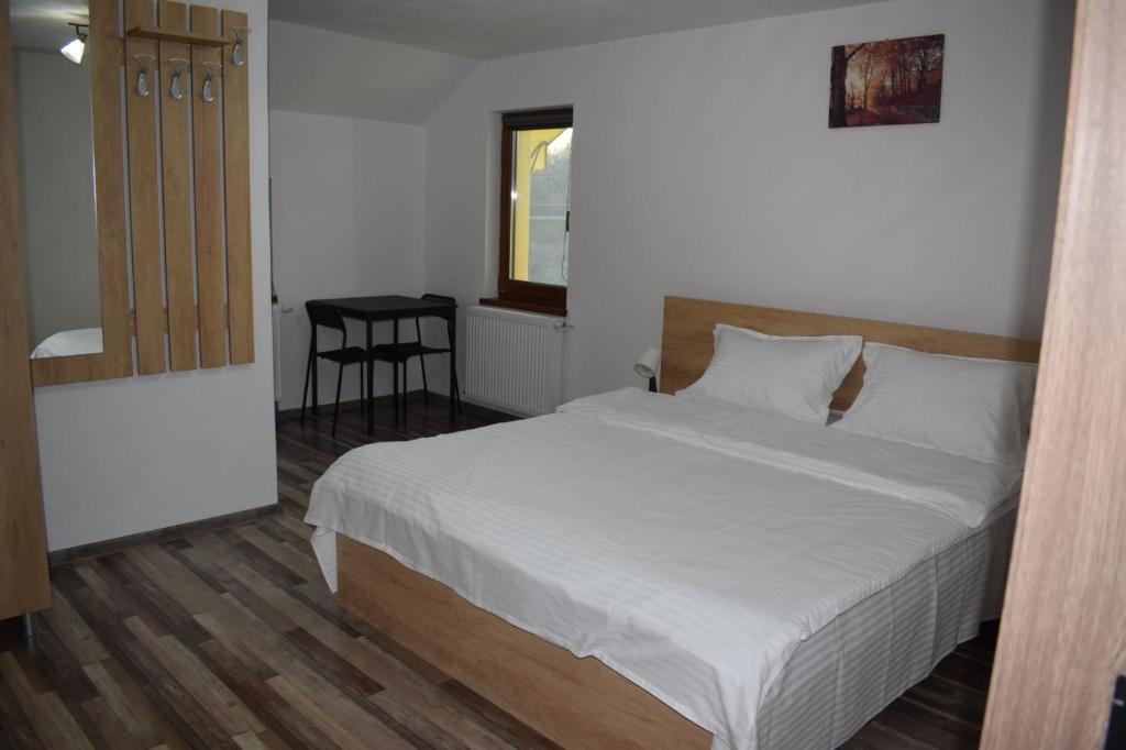 a bedroom with a bed and a table and a chair at Viata la Tara Cerna in Cerna