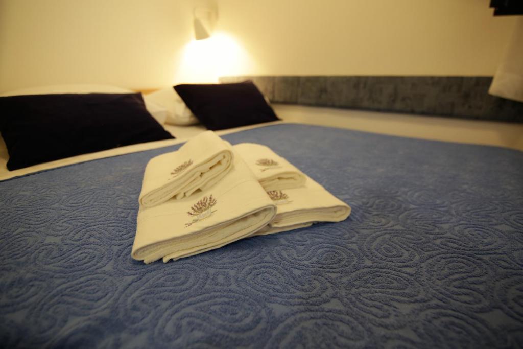 two white towels sitting on top of a bed at Apartment Ljubica Tisno in Tisno