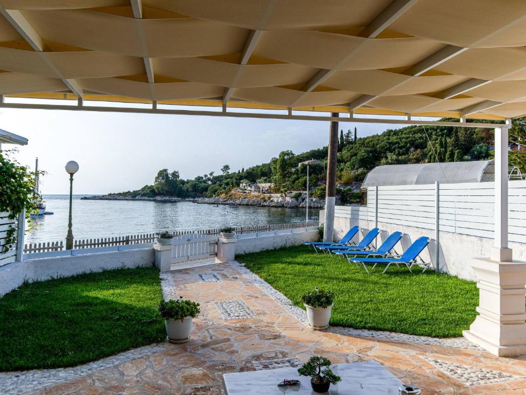 a patio with chairs and a view of the water at Casa Markapela in Kassiopi