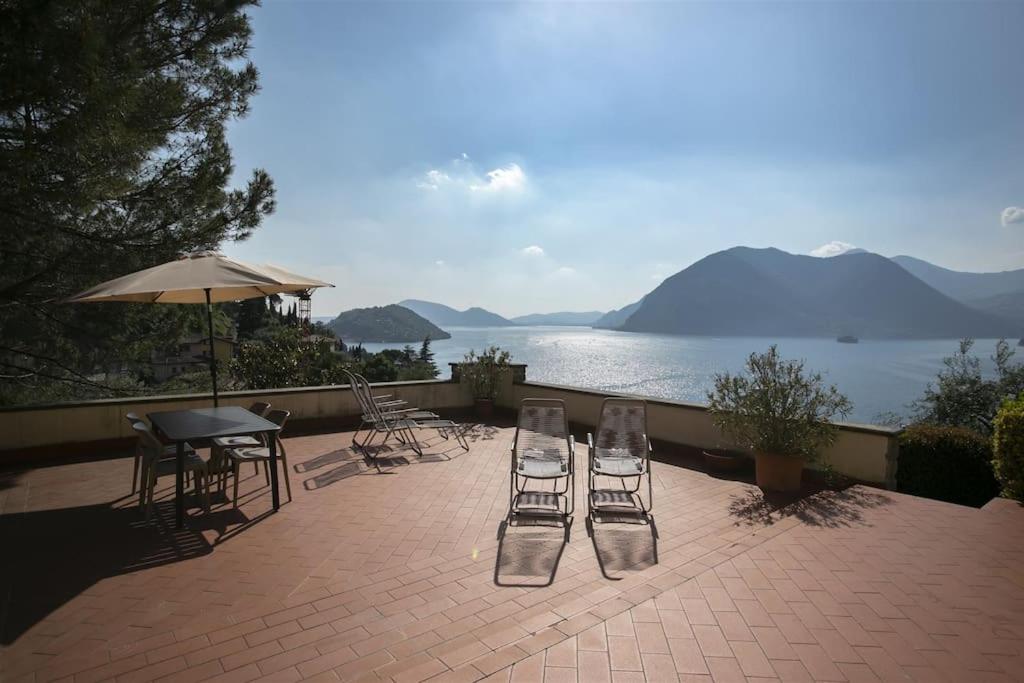 a patio with chairs and a table and a view of the water at IseoLakeRental - Casa Rododendro in Sulzano