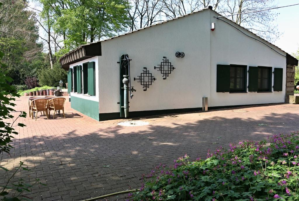 a small white building with a table and chairs at Ferienwohnung Fischerhütte Xanten in Xanten