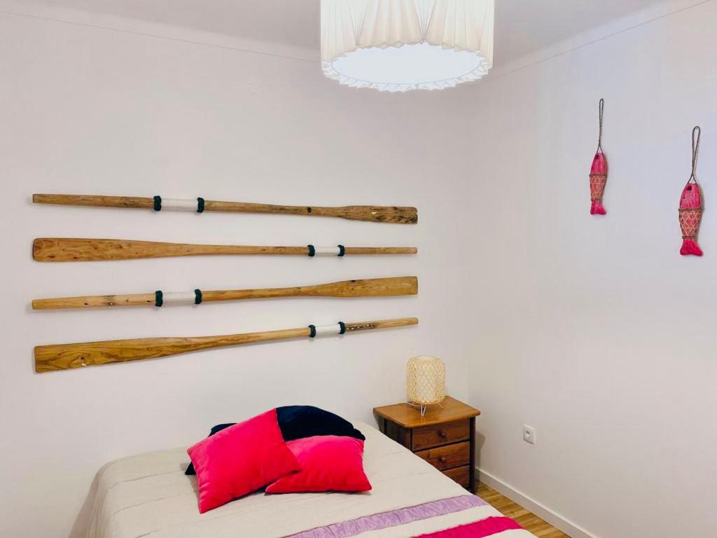 um quarto com uma cama com um monte de troncos na parede em Salty Home’s em Peniche
