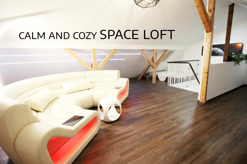 a living room with a white sofa and cozy space lift at SECRET HIDEAWAYS Space Loft Wohndesign auf 2 Etagen l 450m bis Uni in Duisburg