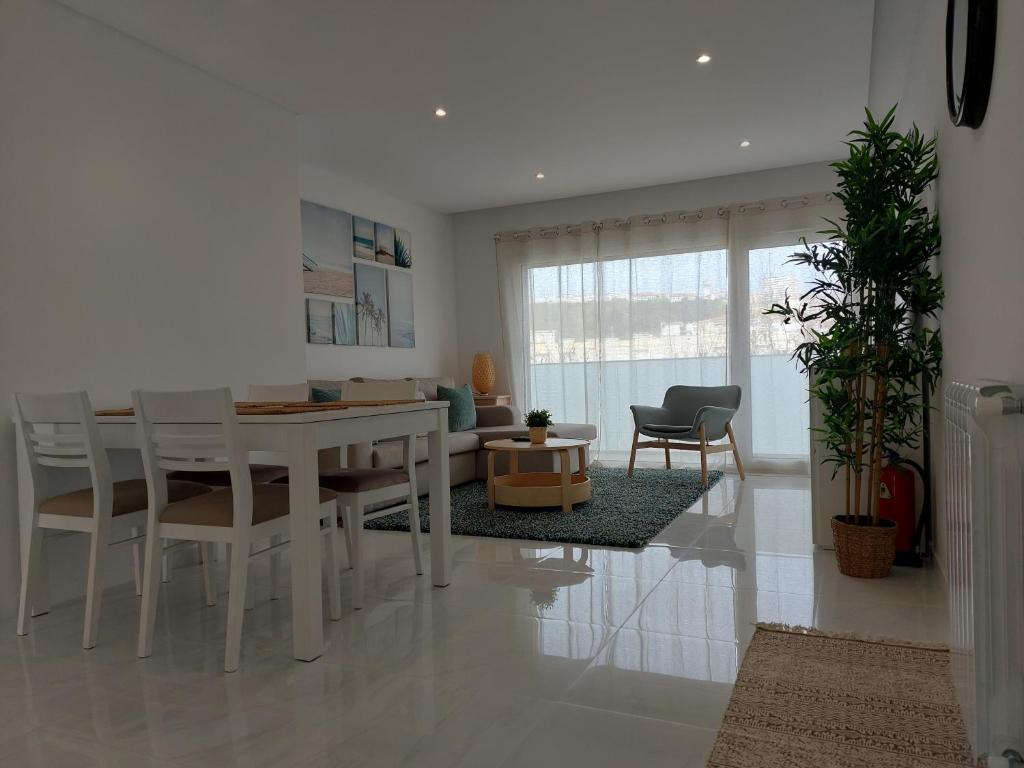 ein Esszimmer und ein Wohnzimmer mit einem Tisch und Stühlen in der Unterkunft Beach Life Apartment, NEW, ELEGANT and COZY in Nazaré
