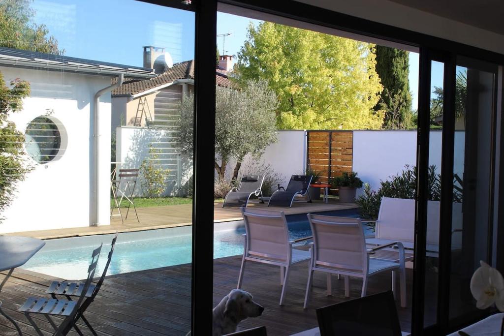un patio avec une table et des chaises et une piscine dans l'établissement La Belle Maison Patio, à Albi