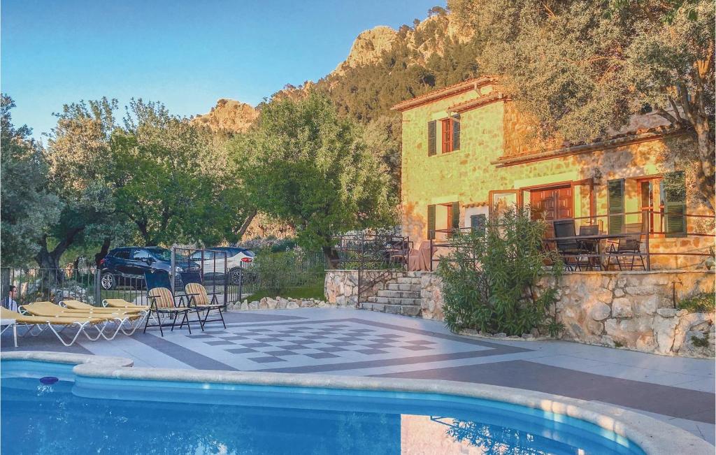 a house with a swimming pool in front of a house at Nice Home In Estellencs With Kitchen in Estellencs