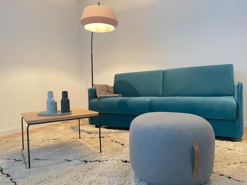 a living room with a blue couch and a table at City Lofts Tegernsee - Moderne Studios zentral gelegen in Bad Wiessee
