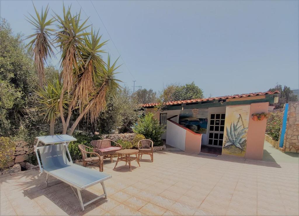 un patio con una silla azul y una casa en Case Pescatori Villette, en Lampedusa