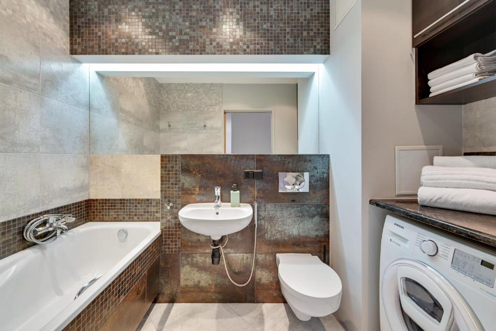 W łazience znajduje się umywalka i pralka. w obiekcie Comfort Apartments Horyzonty w Gdańsku