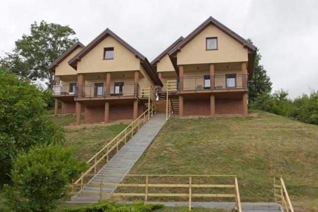 a large house with stairs in front of it at Domki ALEX in Swarzewo