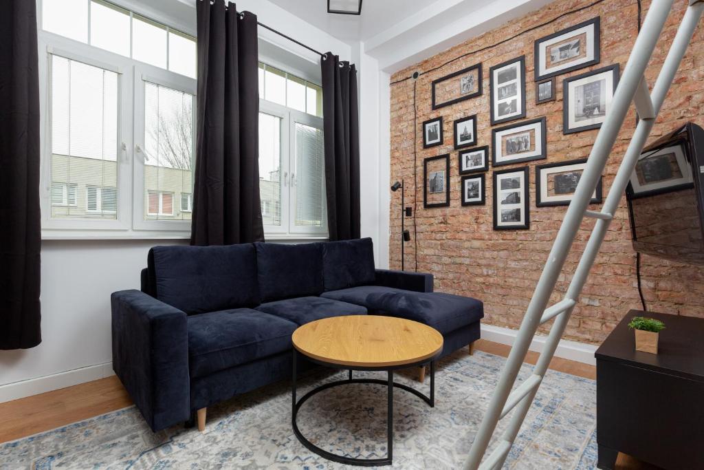 salon z niebieską kanapą i ceglaną ścianą w obiekcie Praga Center Apartments by Renters w Warszawie