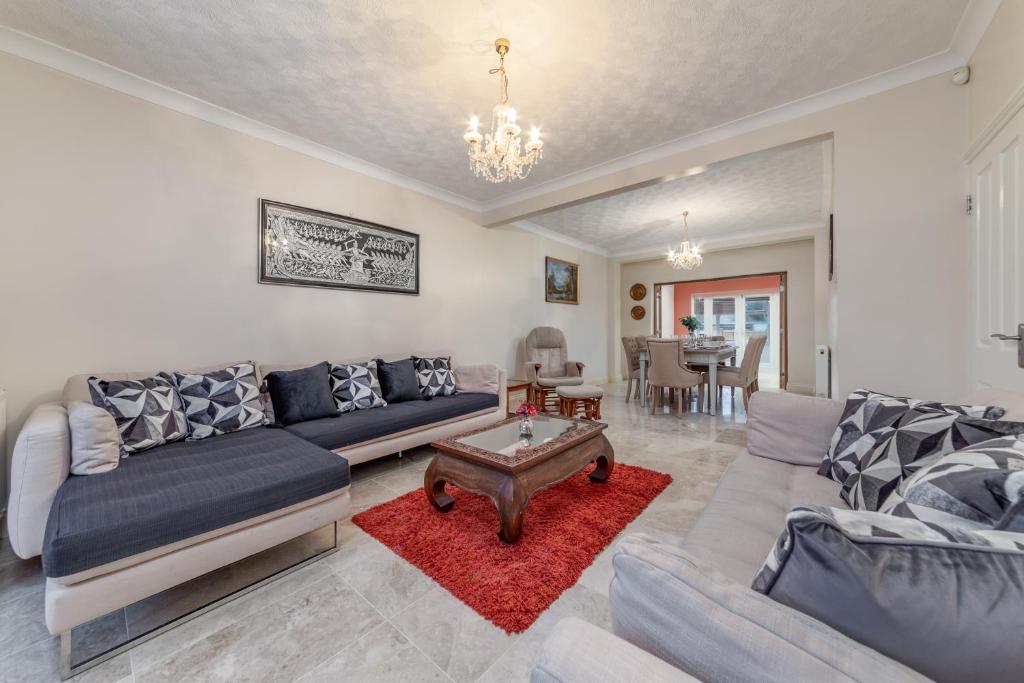 ein Wohnzimmer mit einem Sofa und einem Tisch in der Unterkunft Flourish Apartments - Marlands - Ilford in Redbridge