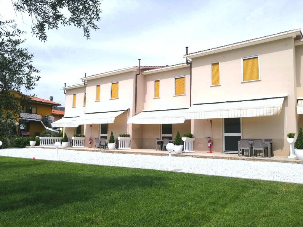 a building with yellow windows and a yard at Le Naiadi Appartamenti in Bolsena