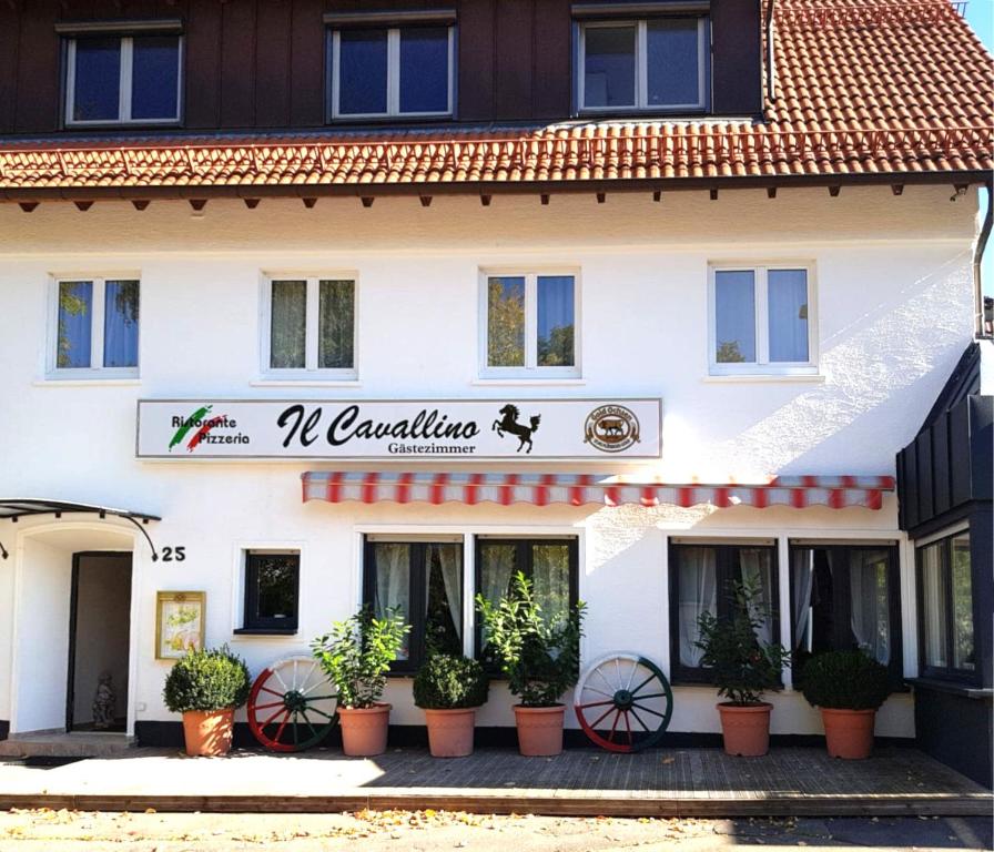 um edifício com vasos de plantas à sua frente em Ristorante Cavallino Gammelshausen em Gammelshausen