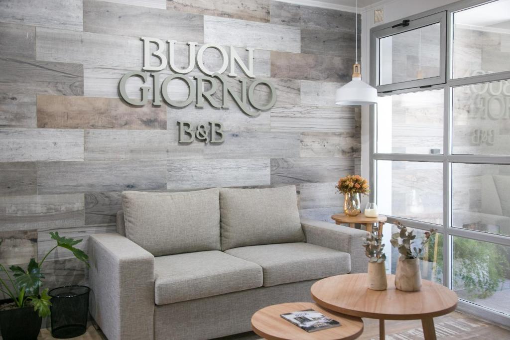 a living room with a couch and a wooden wall at Buongiorno B&B Hotel in Marcos Juárez