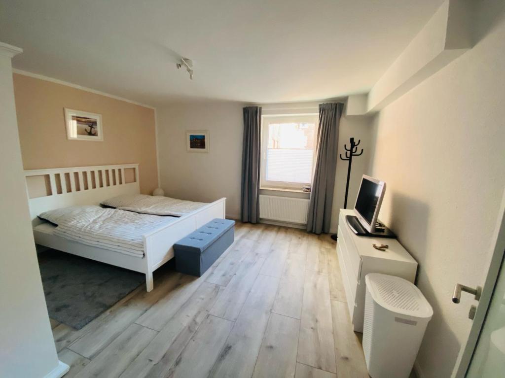 a bedroom with a white bed and a window at Altstadt Ankerplatz in Emden