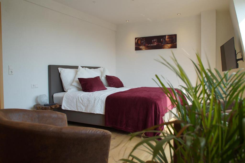 a bedroom with a bed with red and white pillows at Privatweingut Schmidt in Heitersheim