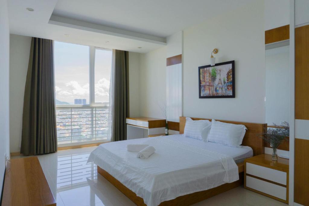 1 dormitorio con cama y ventana grande en Pooh House 7 - 3 bedrooms with city view, en Vung Tau