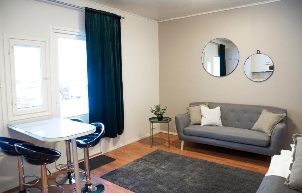 a living room with a couch and a table and a mirror at Motelli Kontio in Kontiolahti