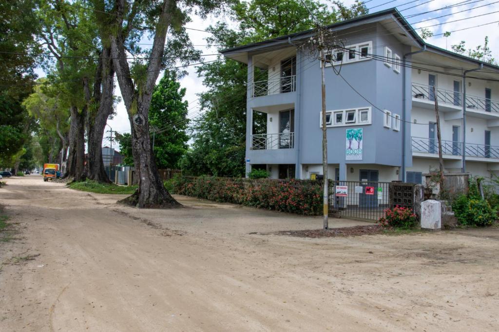 ein Haus an der Seite einer unbefestigten Straße in der Unterkunft Boom Apartments in Paramaribo