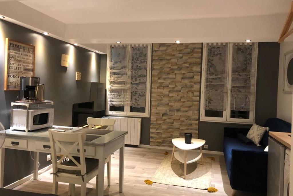 un salon avec une table et un canapé bleu dans l'établissement Cosy Studio Proche Palais Des Papes, à Avignon