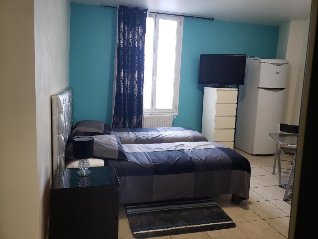 sypialnia z łóżkiem, oknem i telewizorem w obiekcie LE CEDRE w mieście Saint-Denis