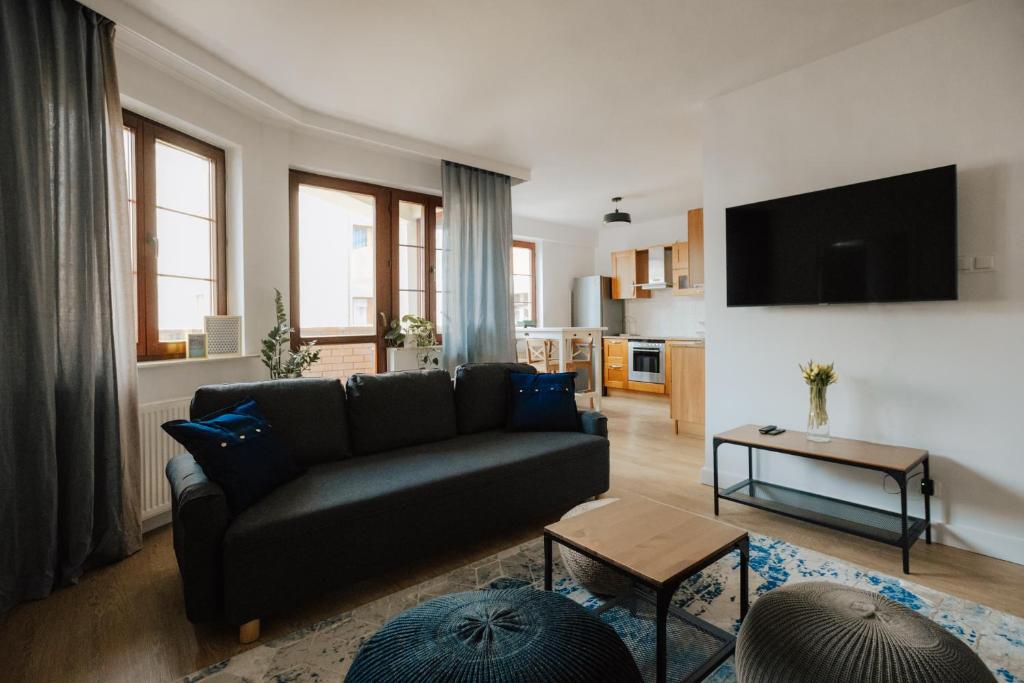 ein Wohnzimmer mit einem Sofa und einem Tisch in der Unterkunft Apartament Rynek Więzienna in Breslau