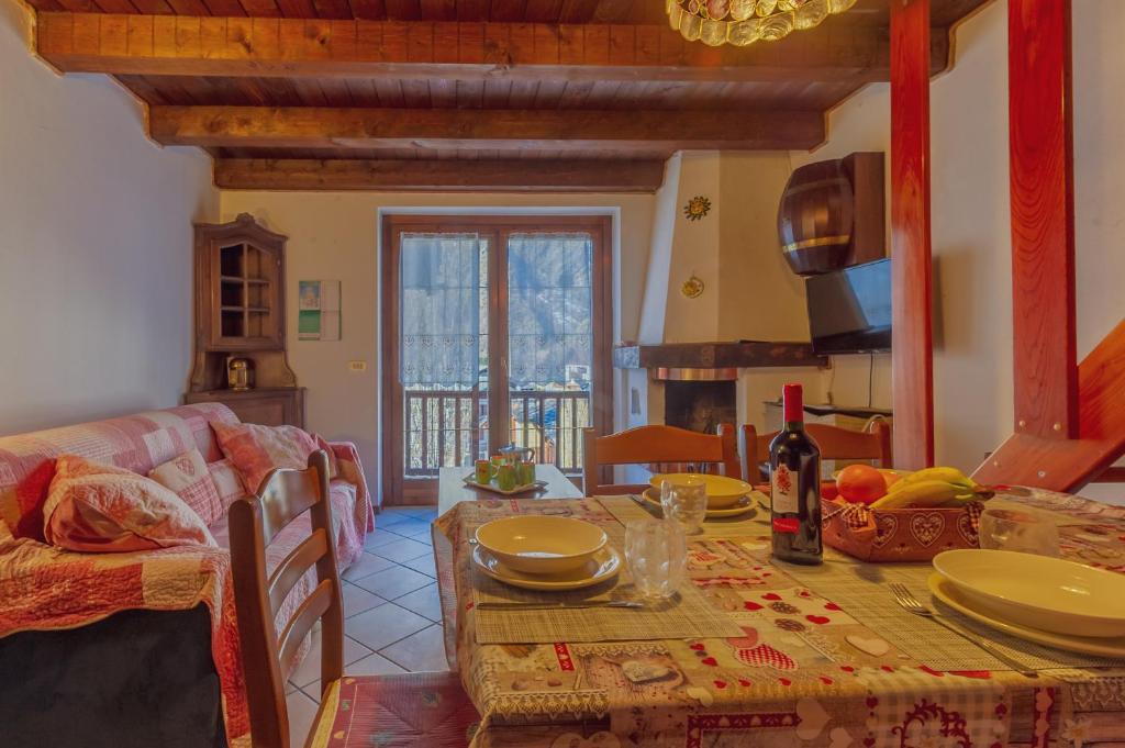 a dining room with a table and a couch at Appartamento Adèle- CIR 0063 in La Thuile