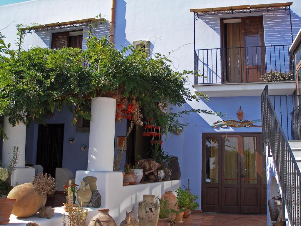 a blue and white building with a door and plants at agriturismo u zu peppino in Lipari