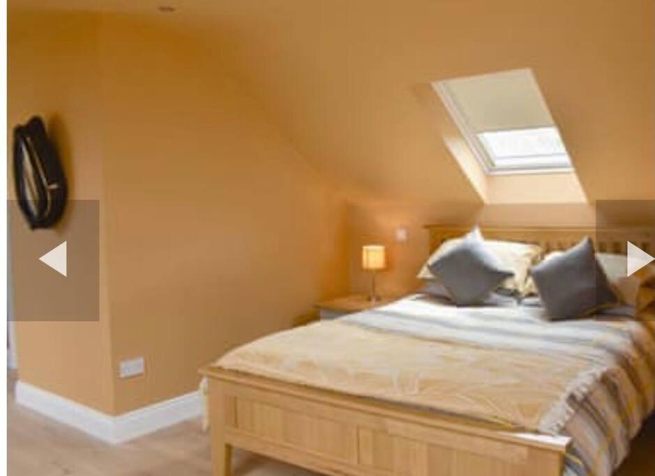 a bedroom with a large bed with a skylight at The Stables Holiday Let in Low Etherley