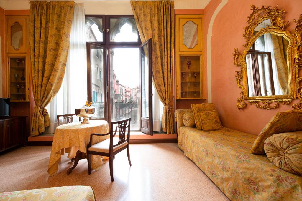 a living room filled with furniture and a window at Hotel San Moisè in Venice