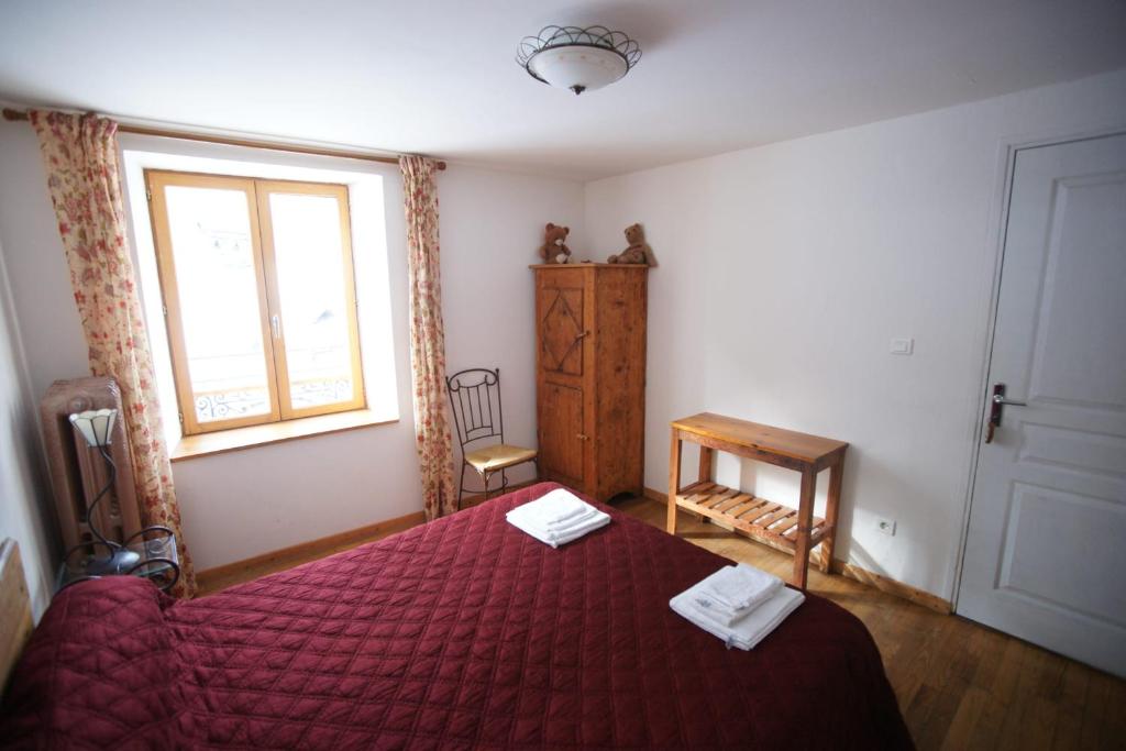 1 dormitorio con cama roja y ventana en Room for two in a house of the XVII century - N2 Chez Jean Pierre en Villar-dʼArène