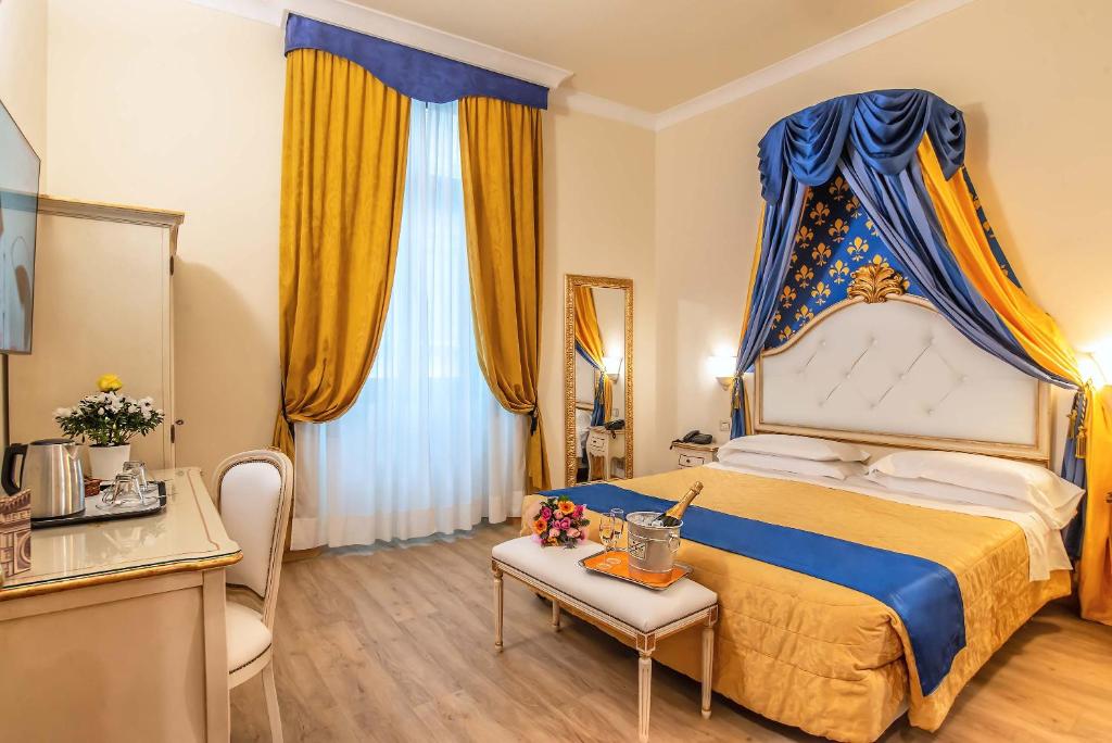 a bedroom with a bed with a blue and yellow canopy at Hotel Porta Faenza in Florence