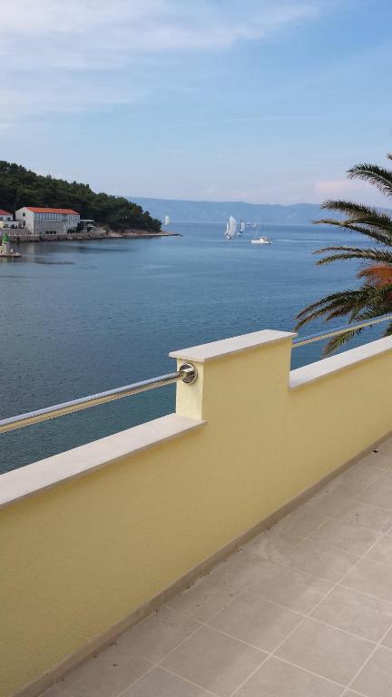 eine gelbe Wand mit Blick auf das Wasser in der Unterkunft Sea view apartment near the beach S2-Jelsa center in Jelsa