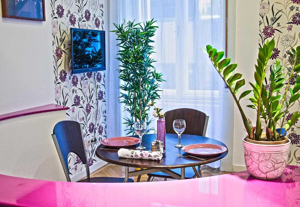 een eetkamer met een tafel en stoelen en een plant bij The Fashion Street Apartment in Boedapest