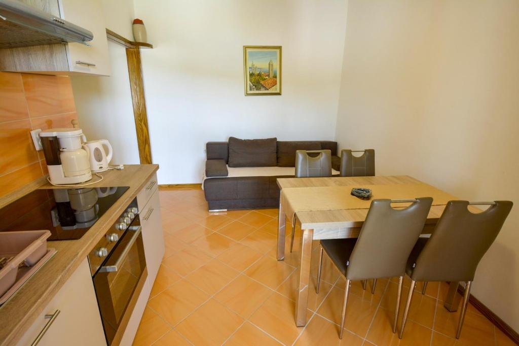 uma cozinha e sala de estar com uma mesa e um sofá em Apartmani Zlata em Supetarska Draga