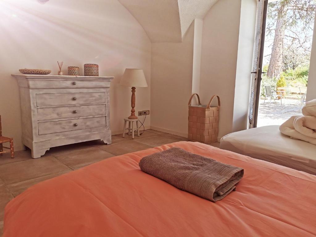 a bedroom with a dresser and a bed with a pillow at La Villa des Charmilles in Vernoux-en-Vivarais