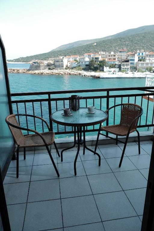 una mesa y sillas en un balcón con vistas al agua en Katerina's rooms en Skala Marion