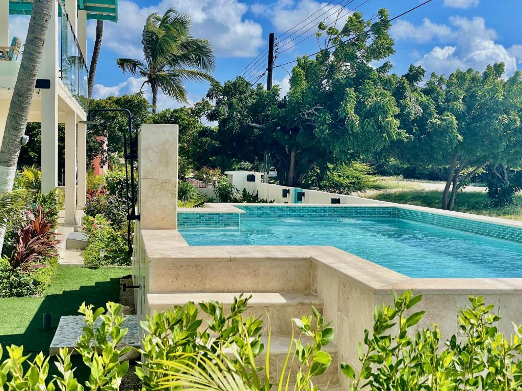 a swimming pool in a yard with trees at Vistalmar Ocean Suites in Oranjestad