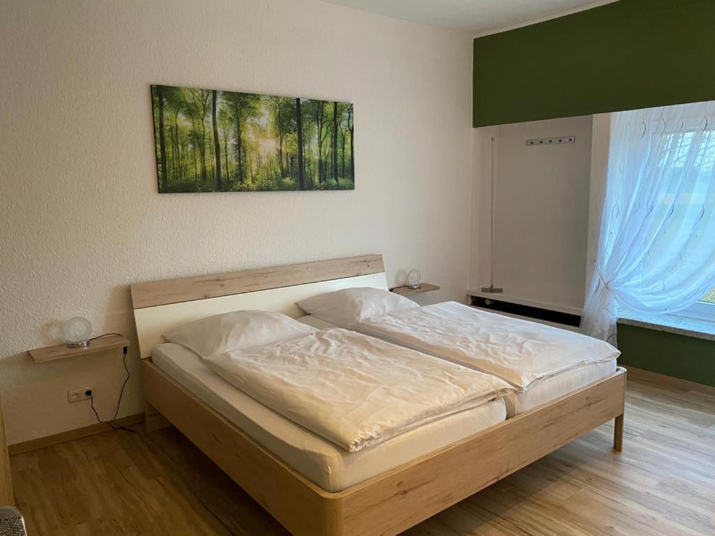 1 cama en un dormitorio con una pintura en la pared en Steimke's Landhotel, en Graue