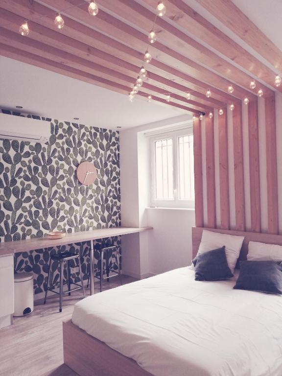 a bedroom with a large bed and a table at Suite 24 Appart'hôtel-3 étoiles in Le Creusot